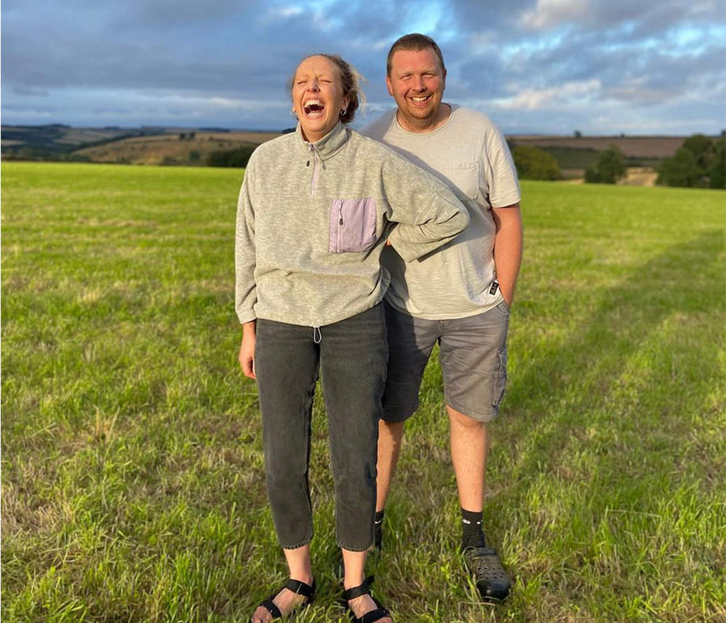 zoe and adam standing in a field on the farm. laughing. Yorkshire farm. Siblings